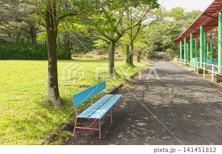 レトロな遊園地の木陰にある青いベンチ、ノスタルジックな公園の風景 レトロな遊園地の木陰にある青いベンチ、ノスタルジックな公園の風景 141451812