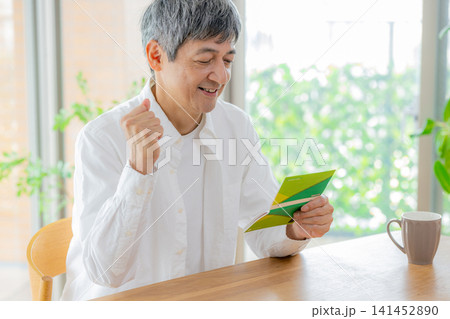 通帳を見るシニア男性 141452890