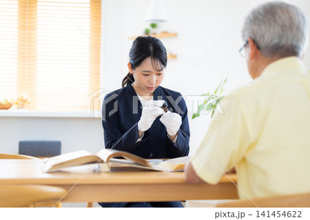 出張買取　訪問先で古銭の鑑定をしている鑑定士　 141454622