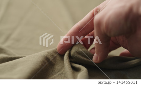 man hand checking green cotton jersey cloth man hand checking green cotton jersey cloth 141455011