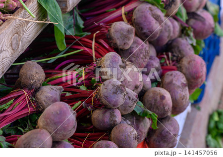 Colorful beets piled together at a vibrant farmers market in the late afternoon sun 141457056