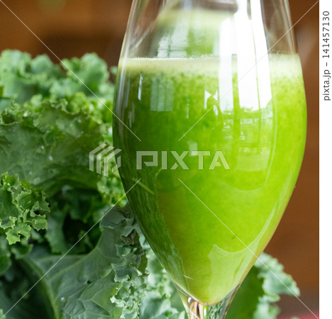 Fresh organic kale smoothie with kale leaves in background. Fresh organic kale smoothie with kale leaves in background. 141457130