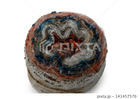 Delicate hand-spun wool craft showcases swirling patterns and vibrant colors in an artistic display Delicate hand-spun wool craft showcases swirling patterns and vibrant colors in an artistic display 141457570