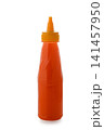 Plastic squeeze bottle filled with orange sauce on a white background 141457950