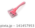 Bright pink grooming tool rests on a clean, white surface aimed at promoting a smooth and effortless pet care experience 141457953