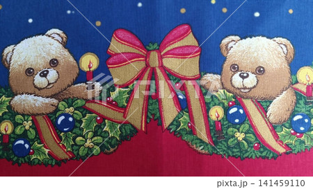 Two smiling teddy bears emerge from a festive holly garland on a starry dark blue background, each holding a lit red candle... 141459110