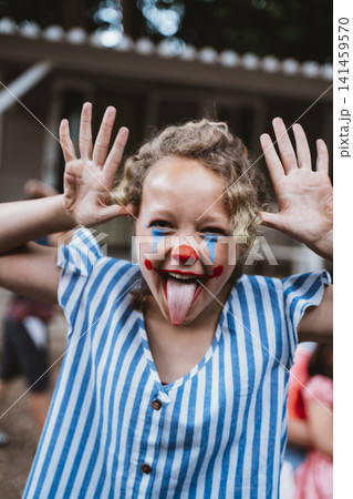 Girl in Clown Makeup Making Funny Faces Outdoors Girl in Clown Makeup Making Funny Faces Outdoors 141459570