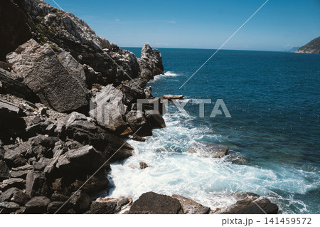 Rocky Coastline with Waves Crashing Against the Shore Rocky Coastline with Waves Crashing Against the Shore 141459572