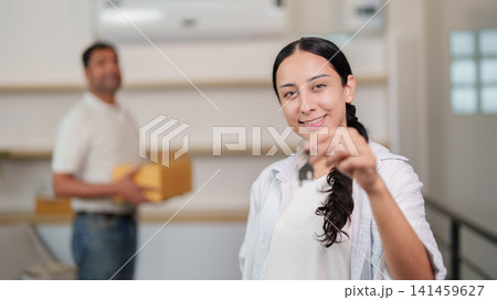 Happy South Asian woman holding key to new home during relocation Happy South Asian woman holding key to new home during relocation 141459627