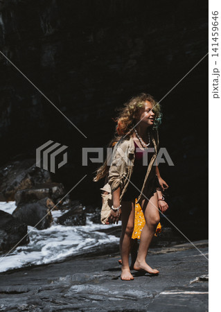 Young Girl Exploring Rocky Beach with Joyful Expression Young Girl Exploring Rocky Beach with Joyful Expression 141459646