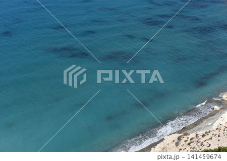 Turquoise sea water texture and gentle waves washing onto a pebble beach slope, Cyprus Turquoise sea water texture and gentle waves washing onto a pebble beach slope, Cyprus 141459674