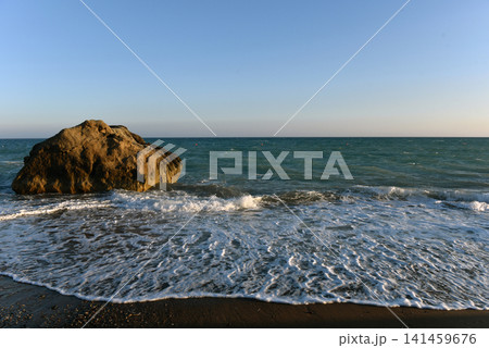 Sea stack on a pebble shore with incoming waves at sunset, Cyprus Sea stack on a pebble shore with incoming waves at sunset, Cyprus 141459676