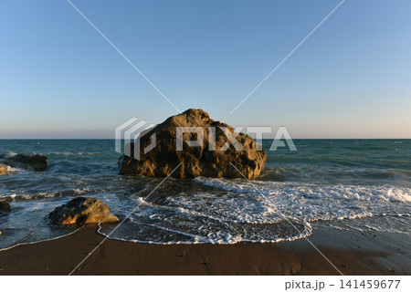 Sea waves crashing wildly over rocky boulders on rocky dark sand shore, Cyprus Sea waves crashing wildly over rocky boulders on rocky dark sand shore, Cyprus 141459677