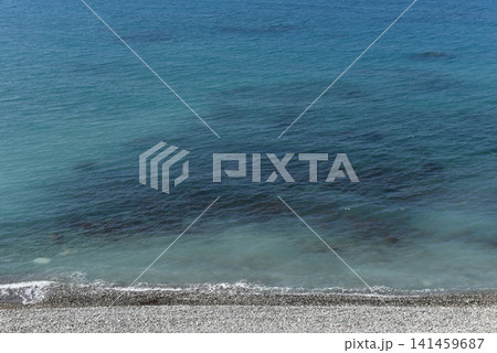 Pebble beach shoreline and vast blue Mediterranean horizon from a high vantage point, Cyprus Pebble beach shoreline and vast blue Mediterranean horizon from a high vantage point, Cyprus 141459687