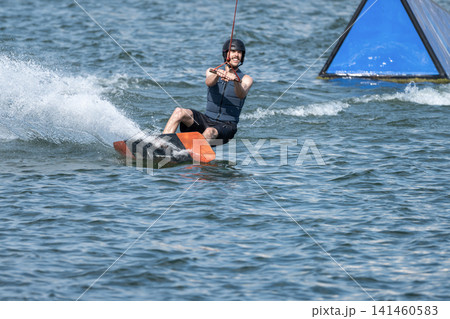 Cable Wakeboarder Riding on Lake in Summer Cable Wakeboarder Riding on Lake in Summer 141460583