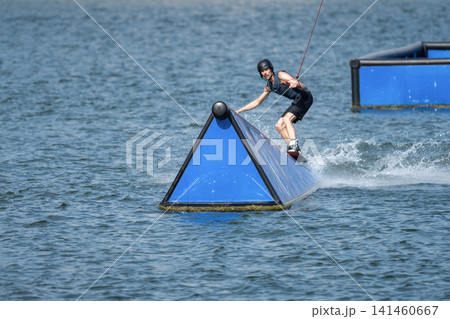 Cable Wakeboarder Riding on Lake in Summer Cable Wakeboarder Riding on Lake in Summer 141460667