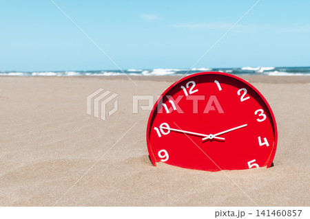 a red clock sinks into the sand on an empty beach 141460857