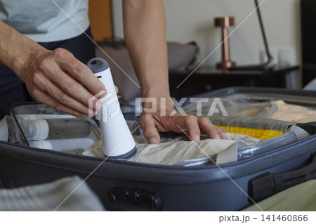 packing a suitcase with vacuum storage bags 141460866