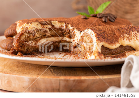 Delicious tiramisu cake on a plate with coffee Delicious tiramisu cake on a plate with coffee 141461358