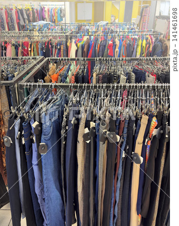 Clothing store, second hand. Rows of clothes on hangers. Multicolored Clothes hanging on racks vertical Clothing store, second hand. Rows of clothes on hangers. Multicolored Clothes hanging on racks vertical 141461698