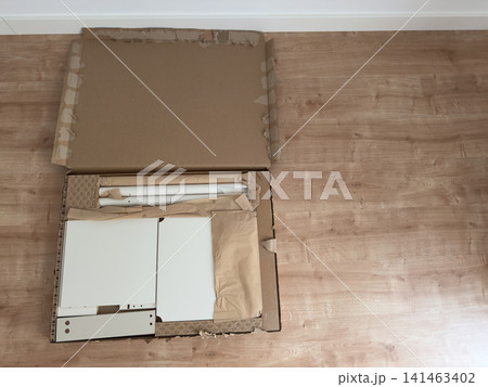 White nightstand panels in an opened flat-pack box, angled view White nightstand panels in an opened flat-pack box, angled view 141463402