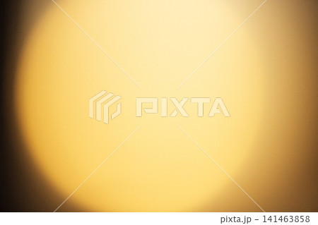 Soft golden light emanating from a circular source, creating a warm glow against a blurred background with subtle gradients and textures 141463858