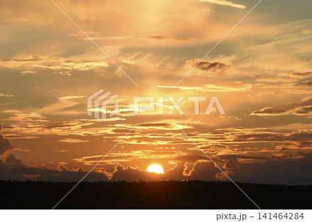 The evening horizon. The sun is in the clouds. A bright yellow-pink sunset. The evening horizon. The sun is in the clouds. A bright yellow-pink sunset. 141464284