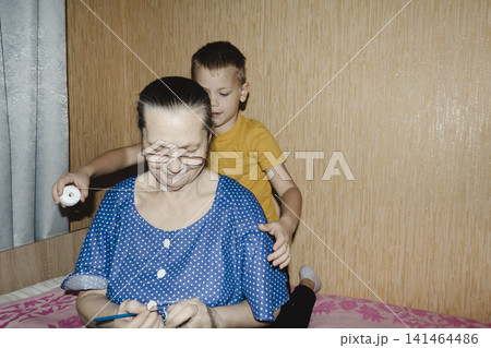 grandmother blue top patiently shows grandson how knit, her hands guiding share quiet, meaningful moment tender scene highlights beauty passing down traditions warmth family ties joy learning together 141464486