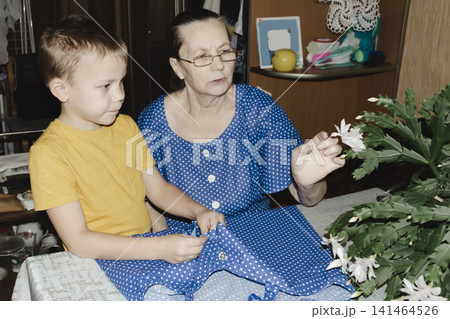 gentle grandmother blue top patiently shows her young grandson how sew piece fabric focused collaboration capturing warmth family learning passing traditions quiet joy creating something together gentle grandmother blue top patiently shows her young grandson how sew piece fabric focused collaboration capturing warmth family learning passing traditions quiet joy creating something together 141464526