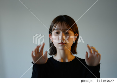 両手を前にかざす女性 両手を前にかざす女性 141465027
