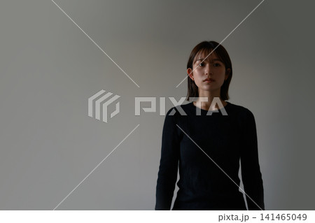 壁を正面に見つめる女性 141465049