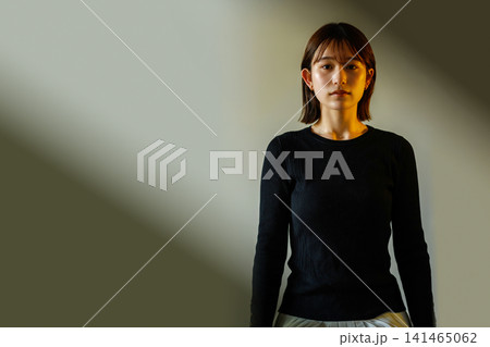 スポットライトを浴びる黒服の女性 スポットライトを浴びる黒服の女性 141465062