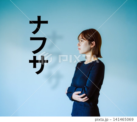 腕を組んで横を向く女性、青い背景 141465069