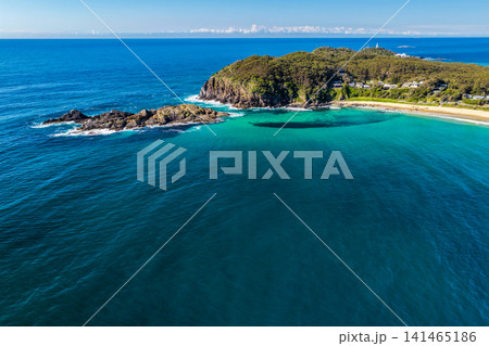 Aerial view of Sugarloaf Point surrounded by crystal-clear turquoise waters and the rugged coastline at Seal Rocks, NSW, Australia, highlighting the natural beauty of this iconic coastal headland. 141465186