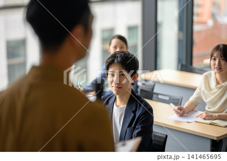会議で真剣な表情で話を聞く若い男性 会議で真剣な表情で話を聞く若い男性 141465695