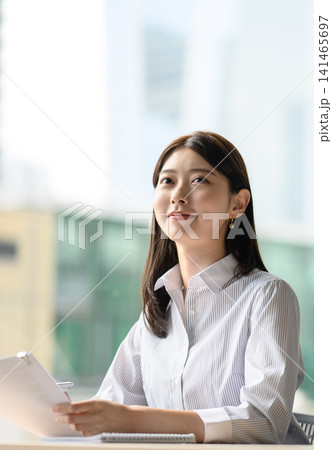 資料を見ながら空を見上げる若い女性 資料を見ながら空を見上げる若い女性 141465697
