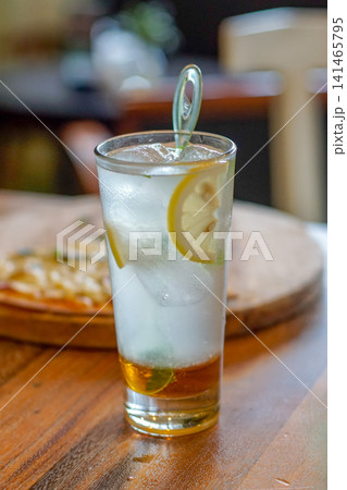 Refreshing Iced Lemon Drink in a Glass with Fresh Lemon Slices, Mint and Ice Cubes on Wooden Table, Cold Summer Beverage at Cafe Refreshing Iced Lemon Drink in a Glass with Fresh Lemon Slices, Mint and Ice Cubes on Wooden Table, Cold Summer Beverage at Cafe 141465795