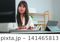 beautiful young business woman working in office 141465813