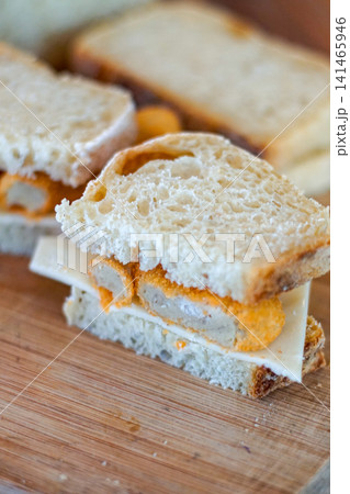 Simple homemade sandwich with fried filling and cheese on rustic bread close up, quick easy meal concept, minimal food styling with selective focus Simple homemade sandwich with fried filling and cheese on rustic bread close up, quick easy meal concept, minimal food styling with selective focus 141465946