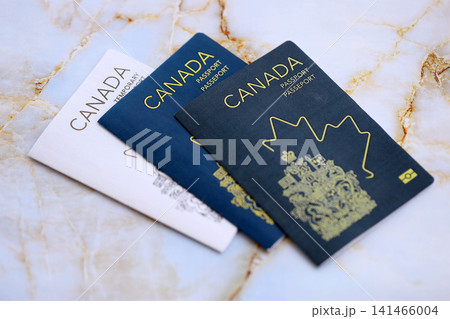 Canadian passports on table close up. Official identification document books for citizens of Canada Canadian passports on table close up. Official identification document books for citizens of Canada 141466004