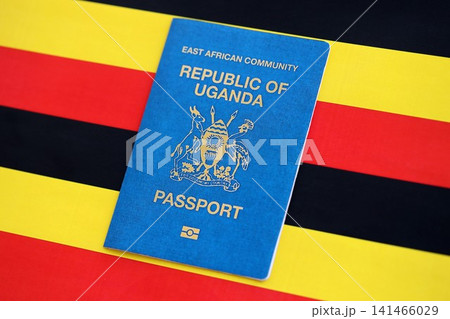 Ugandan passport on flag close up. Official identification document book for citizens of Uganda Ugandan passport on flag close up. Official identification document book for citizens of Uganda 141466029