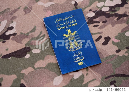 Iraqi passport on table close up. Official identification document book for citizens of Iraq Iraqi passport on table close up. Official identification document book for citizens of Iraq 141466031