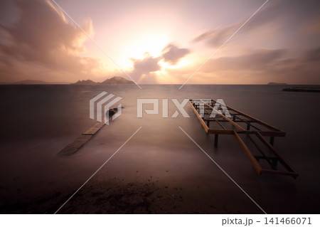 old, rusty abandoned and dismantled pier. sky space is empty. suitable for writing. Seaside town of Turgutreis and spectacular sunshine. Long Exposure shoot. tranquility scene. old, rusty abandoned and dismantled pier. sky space is empty. suitable for writing. Seaside town of Turgutreis and spectacular sunshine. Long Exposure shoot. tranquility scene. 141466071