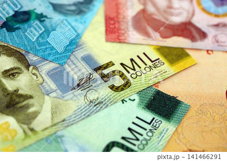 Costa Rican colon money bills pile on table. Costa Rica banknotes of CRC currency close up Costa Rican colon money bills pile on table. Costa Rica banknotes of CRC currency close up 141466291
