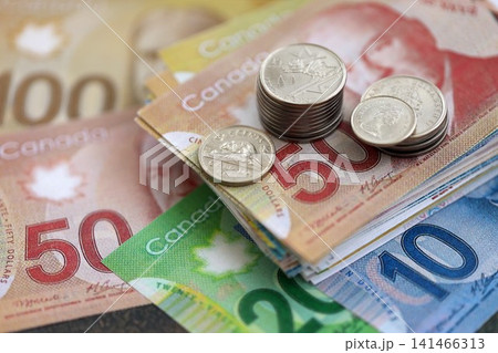 Canadian dollar money bills and cent coins pile on table. Canada coins on banknotes of CAD currency 141466313