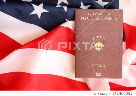 Slovenia passport on big waving flag of United States of America. US Visa and immigration Slovenia passport on big waving flag of United States of America. US Visa and immigration 141466383