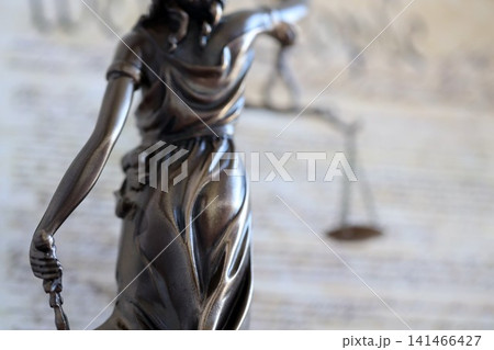 Lady Justice statue on background of US Constitution. Lawsuit and punishment in USA Lady Justice statue on background of US Constitution. Lawsuit and punishment in USA 141466427