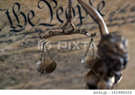 Dark scene with Lady Justice and background of Constitution page. Lawsuit and judgement in US Dark scene with Lady Justice and background of Constitution page. Lawsuit and judgement in US 141466428
