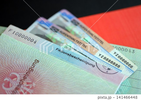 German Permanent resident card and temporary document lies on Germany flag German Permanent resident card and temporary document lies on Germany flag 141466448