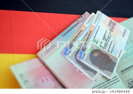 German Permanent resident card and temporary document lies on Germany flag German Permanent resident card and temporary document lies on Germany flag 141466449